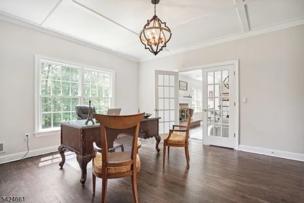 a dining room with furniture a chandelier and wooden floor
