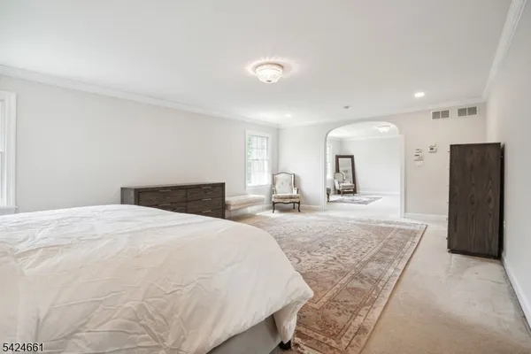 a large bedroom with a bed and a mirror