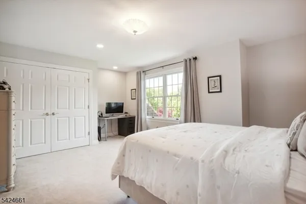 a spacious bedroom with a bed and a window