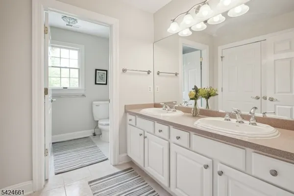 a spacious bathroom with a double vanity sink mirror and toilet