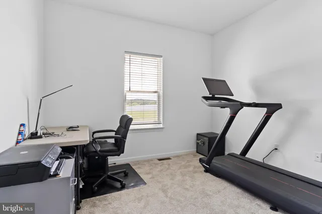 a view of a workspace with furniture and a window