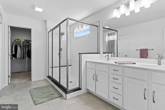 a bathroom with a double vanity sink mirror and shower