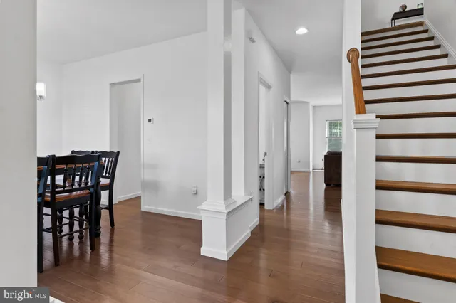 a view of a hallway with wooden floor and staircase