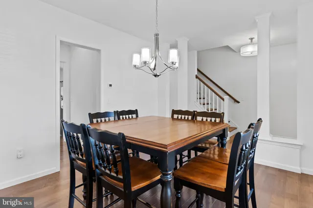 a dining room with furniture a chandelier and wooden floor