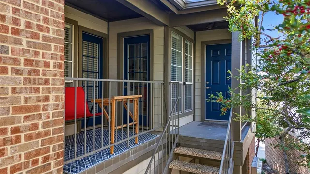 a view of a brick house with a large window and potted plants