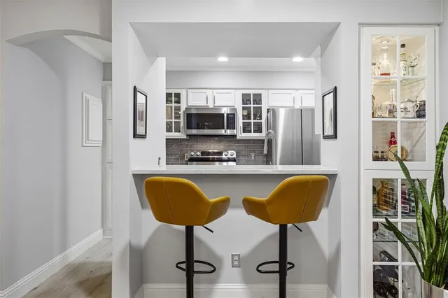 a kitchen with stainless steel appliances granite countertop a refrigerator and a stove top oven