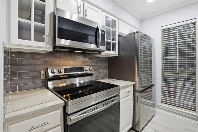 a kitchen with stainless steel appliances granite countertop a stove and a microwave