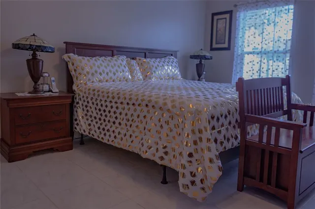 a bedroom with a bed and a lamp next to a window