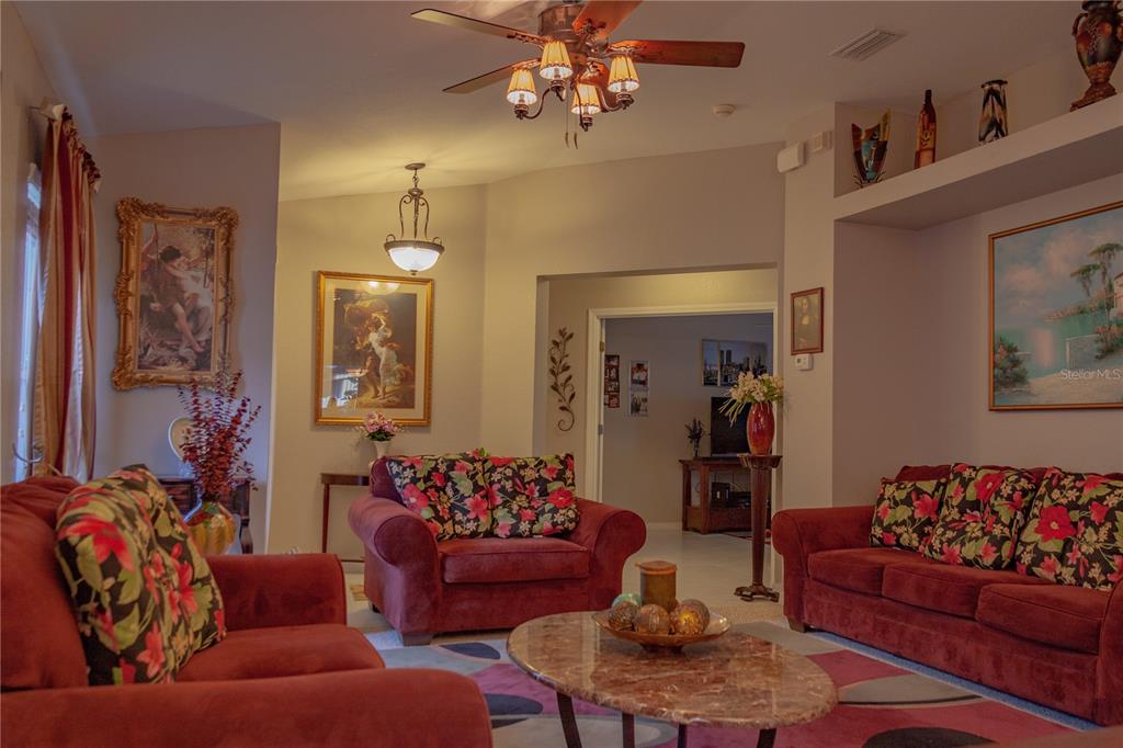 11241 Cocoa Beach Drive Riverview, FL 33569 - Photo 5 of 36 a living room with furniture and a chandelier