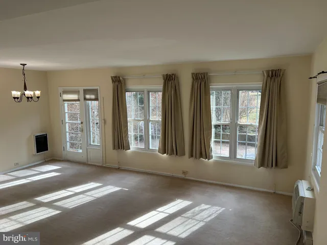 a view of an empty room with a fireplace and a window