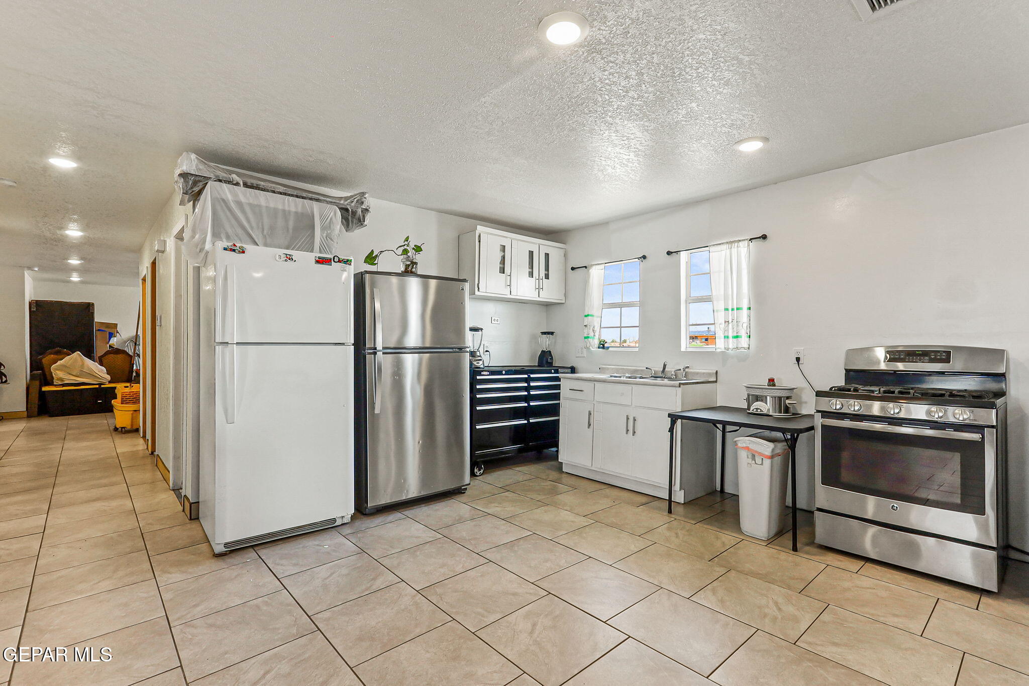 13419 Mendoza Road San Elizario, TX 79849 - Photo 13 of 55 a kitchen with a refrigerator sink and cabinets