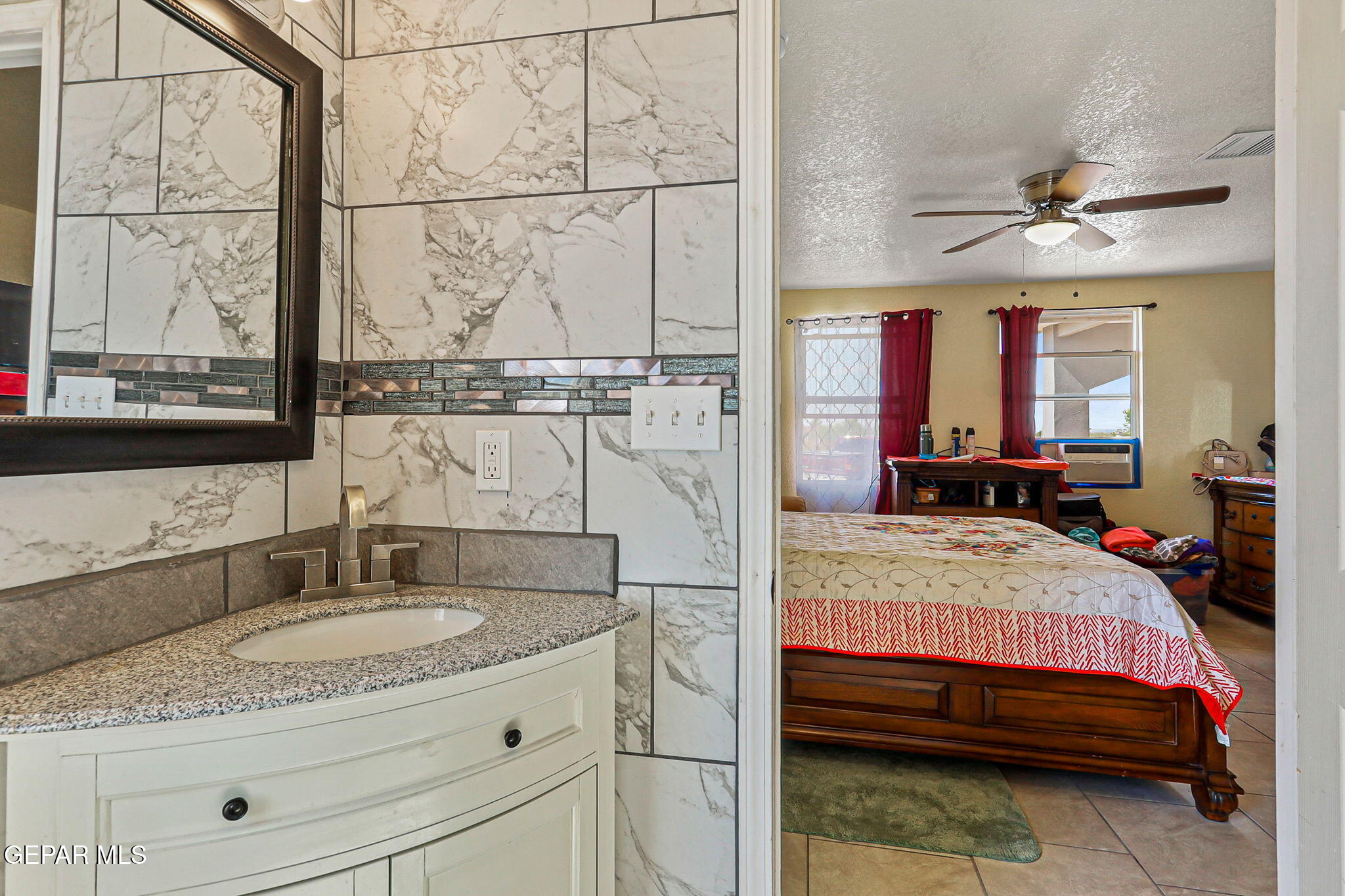 13419 Mendoza Road San Elizario, TX 79849 - Photo 20 of 55 a en suite bathroom with a granite countertop sink and a mirror