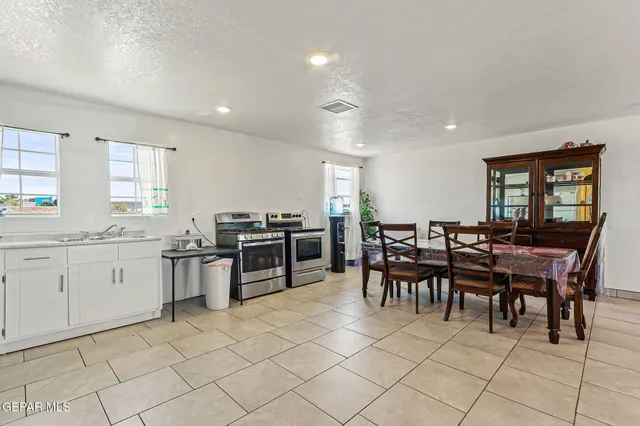 a kitchen with sink and chairs