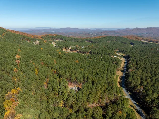 a dining room with stainless steel appliances kitchen island granite countertop a table chairs and a refrigerator