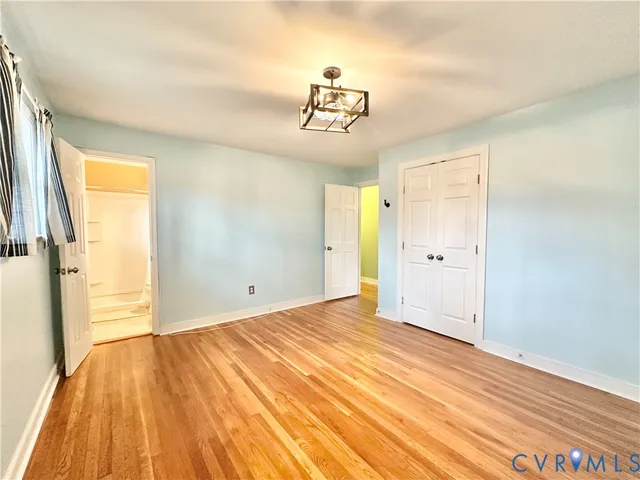 a view of a room with wooden floor and a ceiling fan