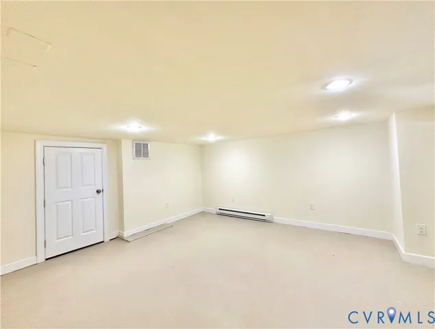 a view of a big room with wooden floor and windows