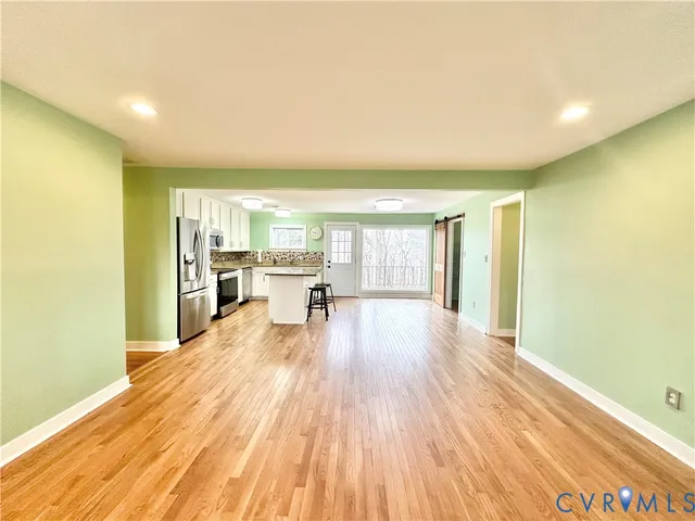 a view of a living room a kitchen with wooden floor