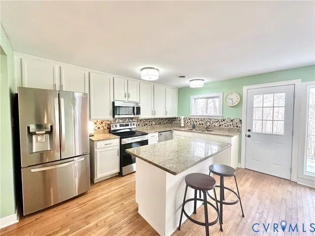 a open kitchen with white cabinets and stainless steel appliances