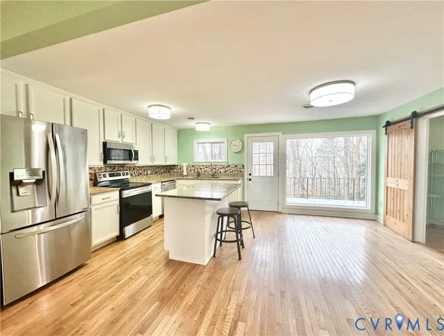 a kitchen with stainless steel appliances granite countertop a stove and a refrigerator