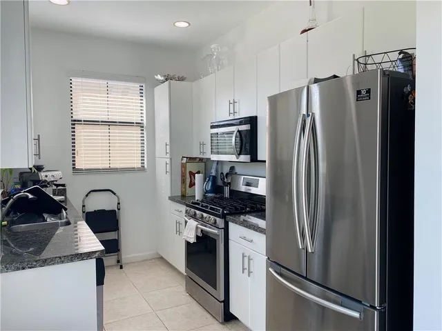 a kitchen with stainless steel appliances a refrigerator sink and stove