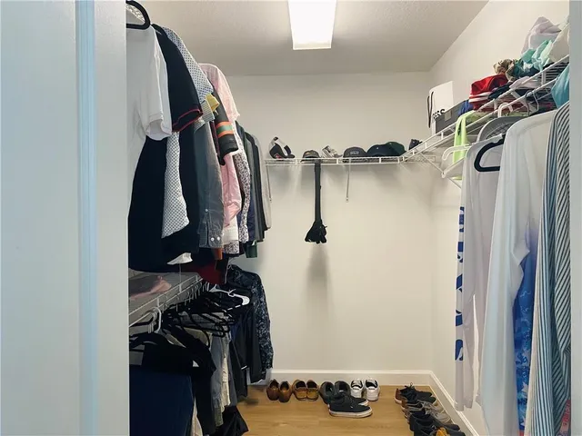 a view of walk in closet with clothes and shoes