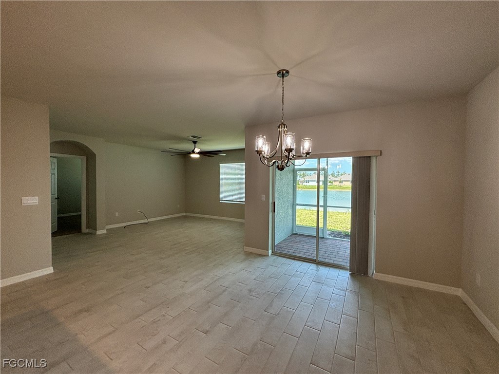 20461 Camino Torcido Loop North Fort Myers, FL 33917 - Photo 11 of 17 an empty room with chandelier fan and windows