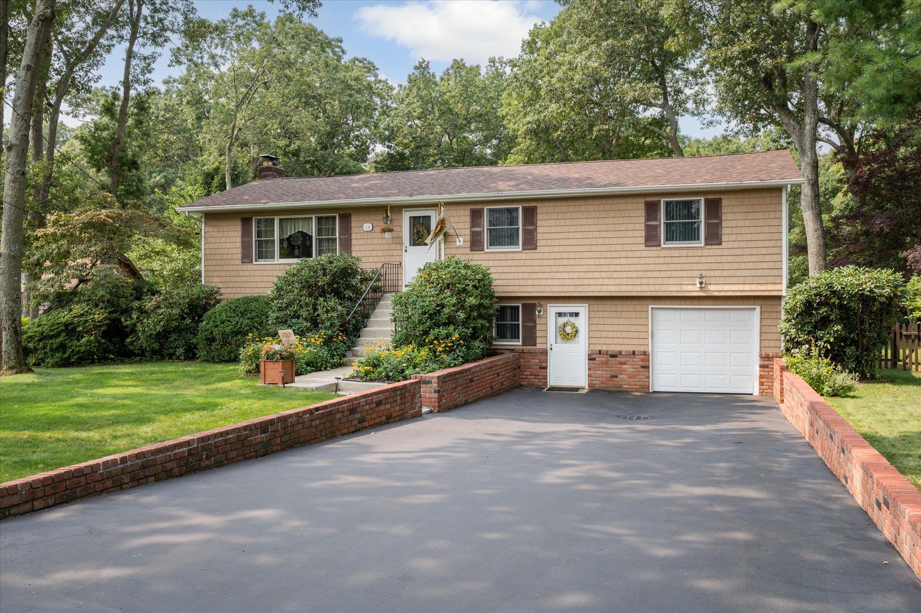 View of front of property featuring a garage and a front lawn