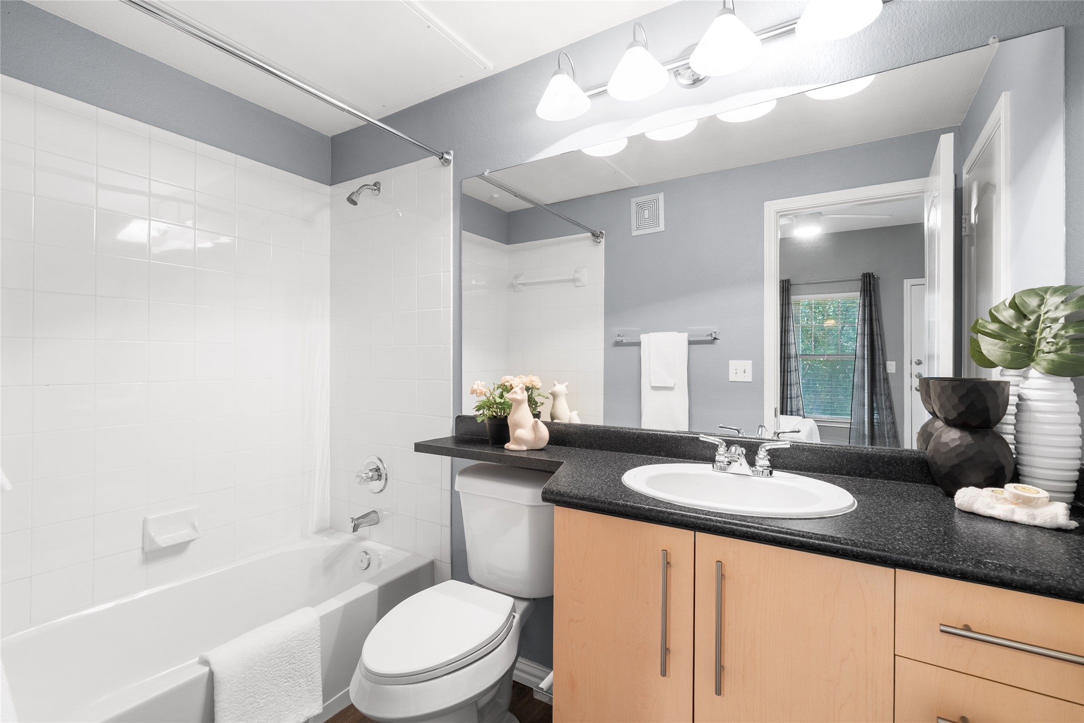 11203 Ranch Road 2222, Unit 1402 Austin, TX 78732 - Photo 17 of 22 Functional ensuite bathroom featuring a shower-tub combo and a wood vanity