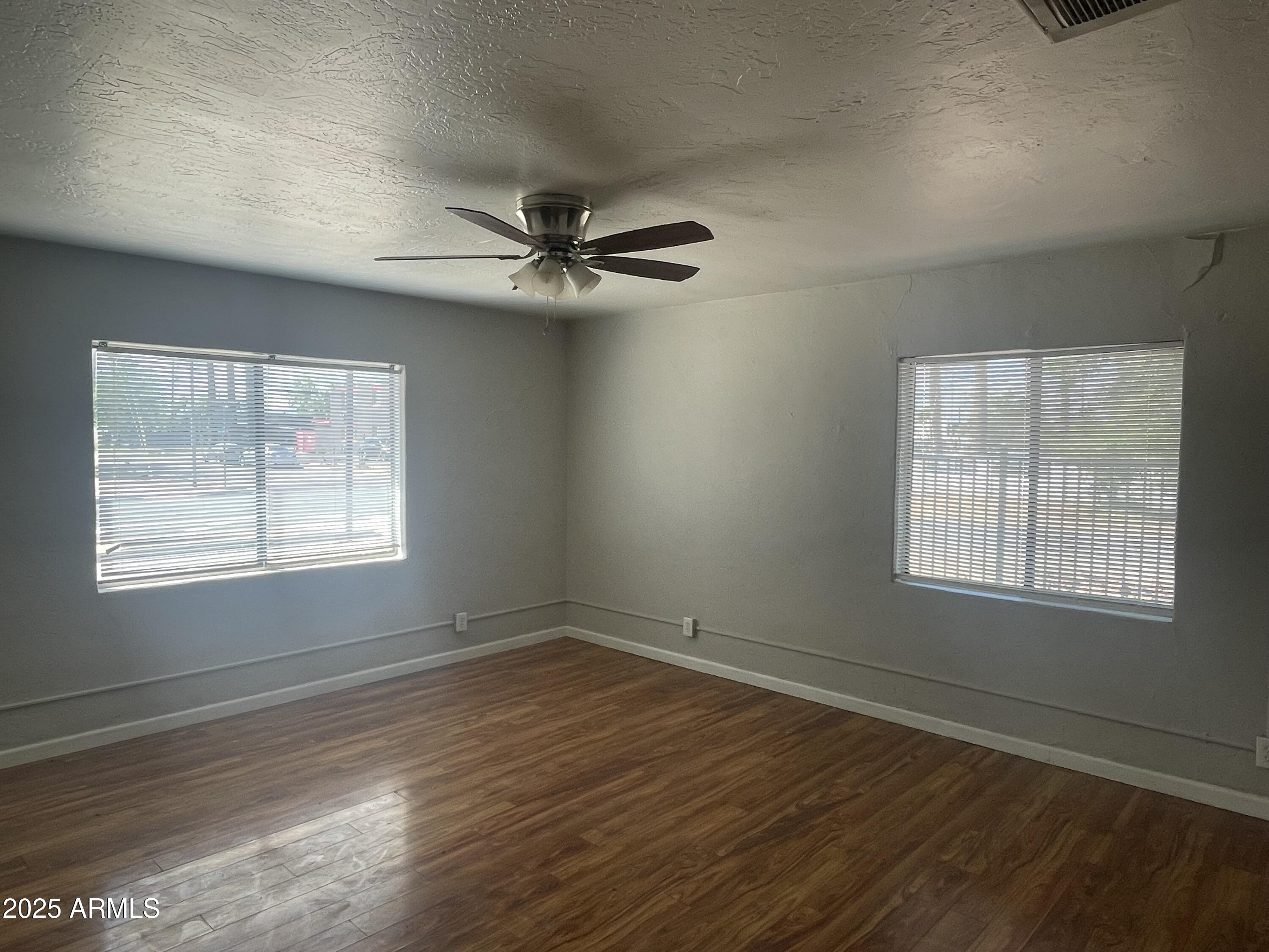 1226 West Roosevelt Street Phoenix, AZ 85007 - Photo 1 of 11 a view of an empty room with wooden floor and a window