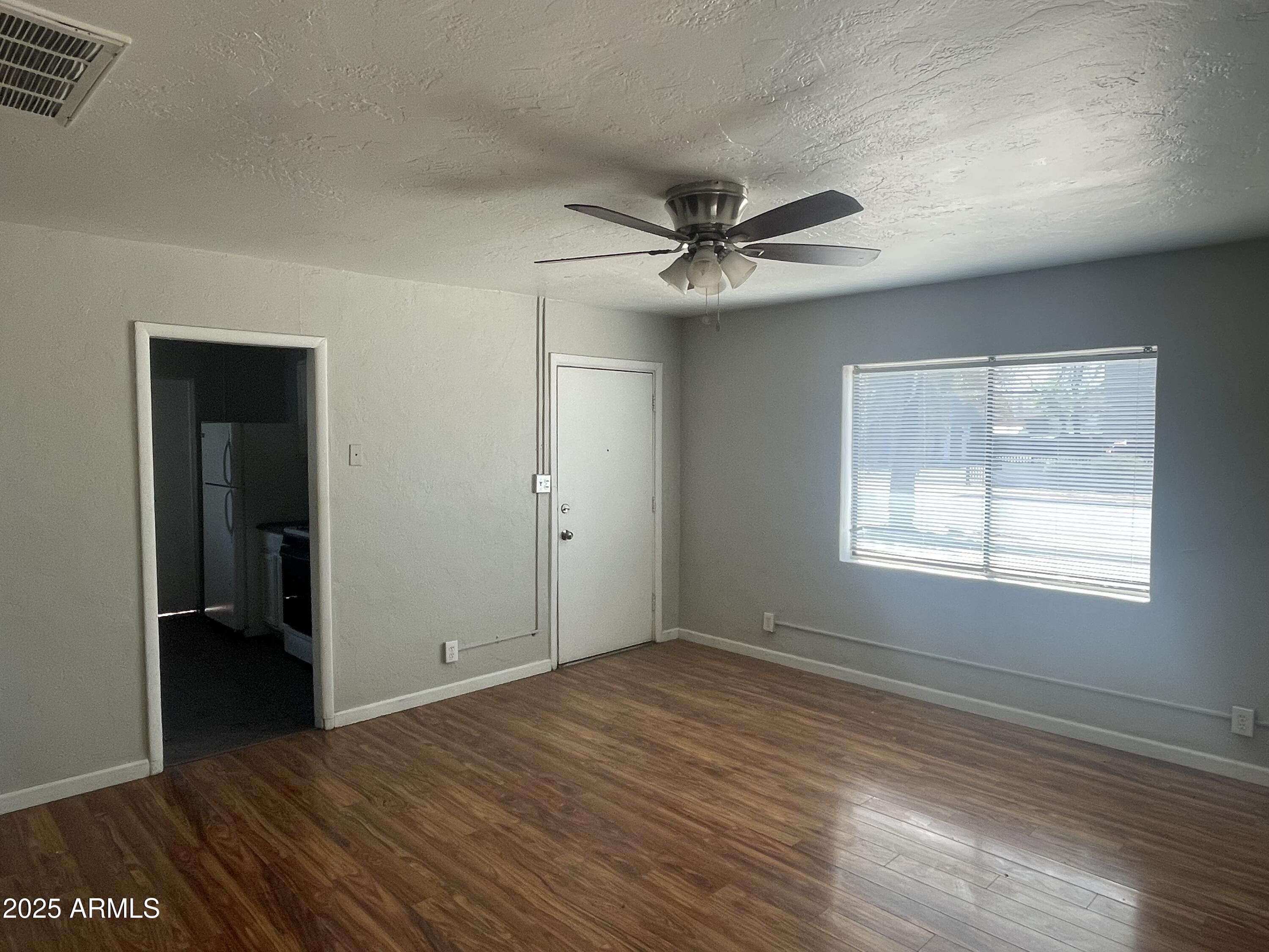 1226 West Roosevelt Street Phoenix, AZ 85007 - Photo 3 of 11 a view of empty room with wooden floor and fan