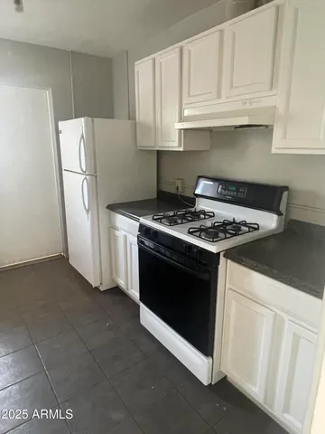 a stove top oven sitting inside of a kitchen