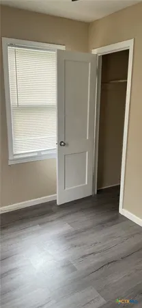 an empty room with window and closet area