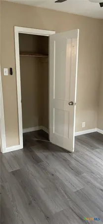 an empty room with wooden floor and closet