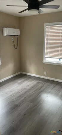 a view of a room with wooden floor and windows