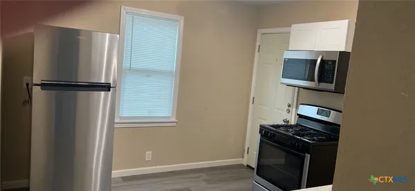 a metallic refrigerator freezer sitting in a kitchen