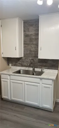 a view with granite countertop a sink and a microwave