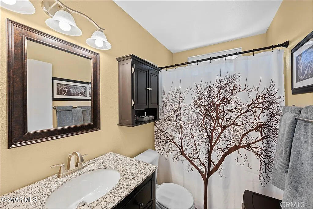 4492 Apricot Road, Unit B Simi Valley, CA 93063 - Photo 20 of 24 a bathroom with a granite countertop sink a mirror and a shower