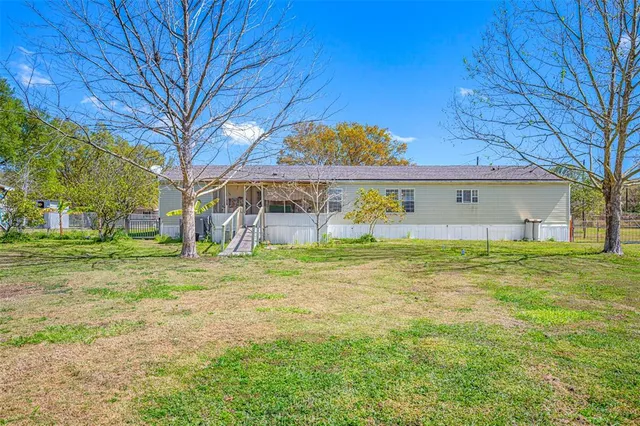 a view of a yard with plants and wooden fence