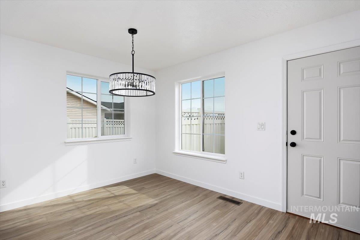 1897 Hampton Way Twin Falls, ID 83301 - Photo 12 of 48 Unfurnished dining area with healthy amount of natural light, light wood-type flooring, and suspended lighting