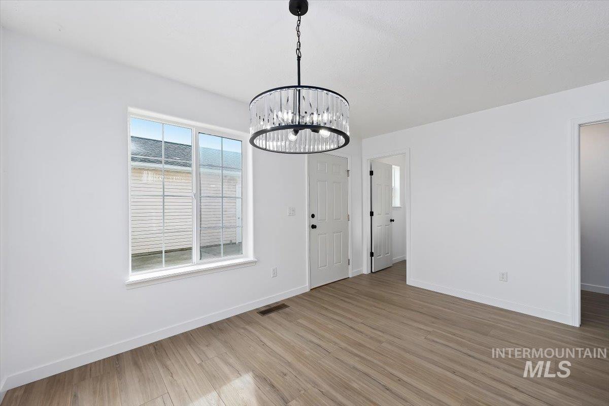 1897 Hampton Way Twin Falls, ID 83301 - Photo 13 of 48 Unfurnished dining area with a chandelier and light wood finished floors