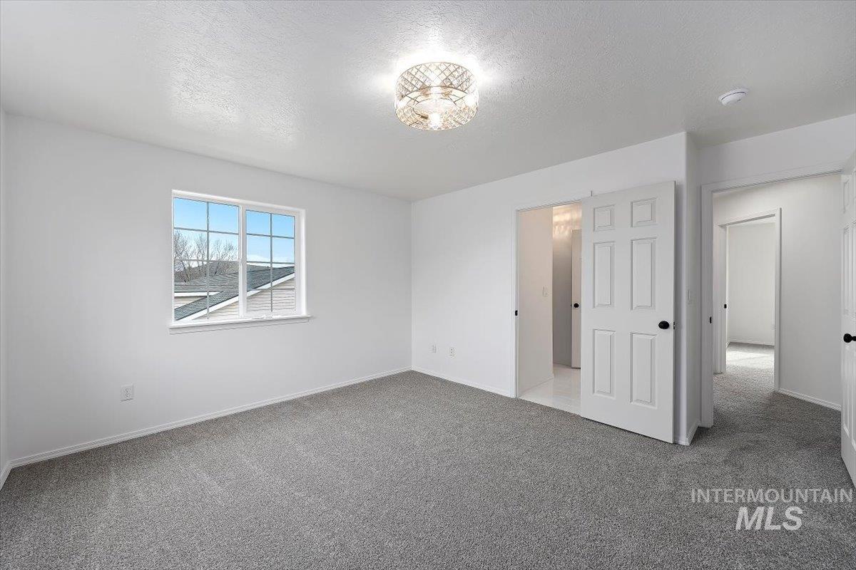 1897 Hampton Way Twin Falls, ID 83301 - Photo 18 of 48 Unfurnished bedroom with light carpet and a textured ceiling
