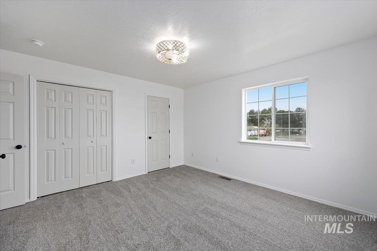 1897 Hampton Way Twin Falls, ID 83301 - Photo 21 of 48 Unfurnished bedroom featuring a closet, carpet, and a textured ceiling
