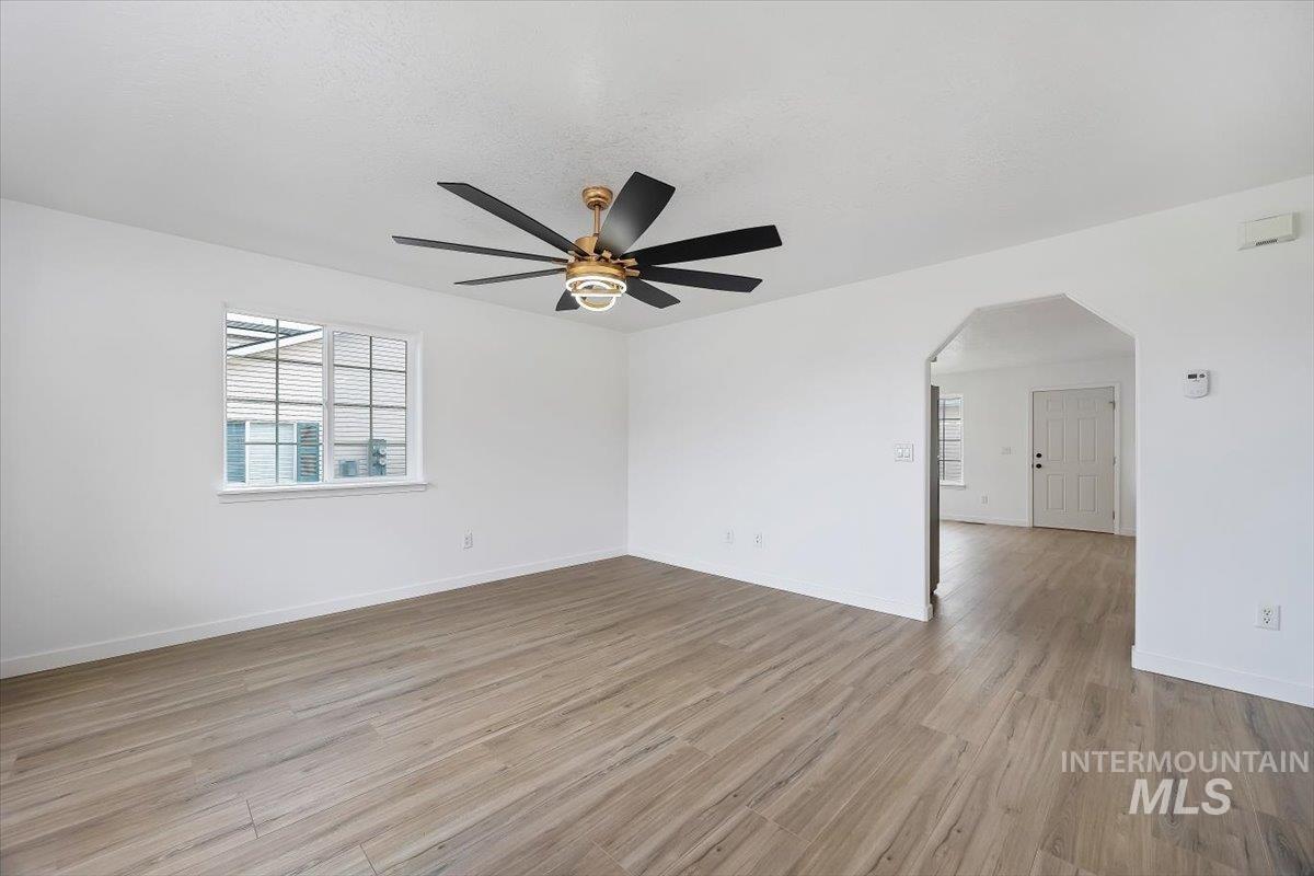 1897 Hampton Way Twin Falls, ID 83301 - Photo 4 of 48 Empty room featuring arched walkways, light wood-style floors, plenty of natural light, and ceiling fan