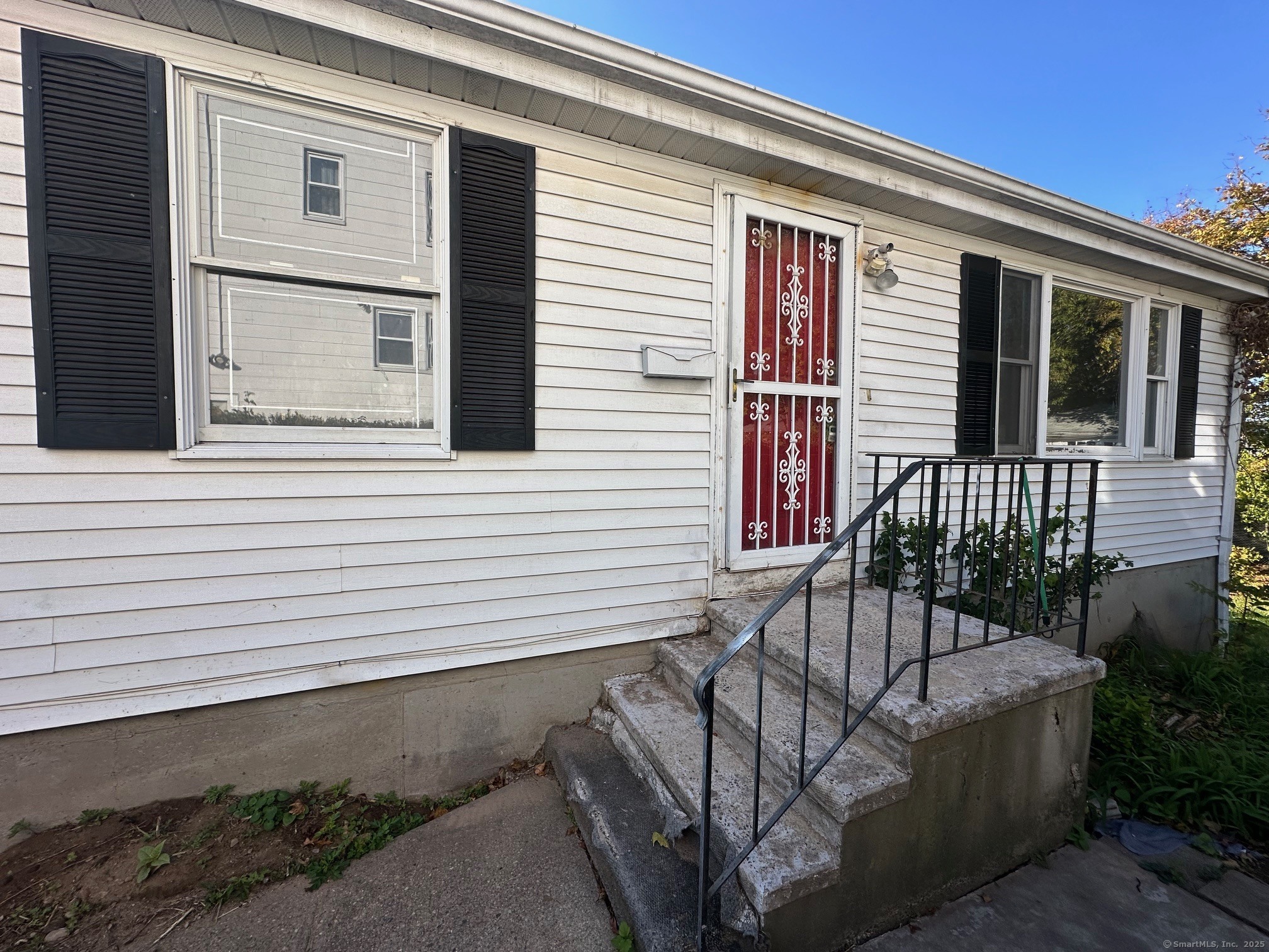 a view of a house with a small yard and wooden floor and fence