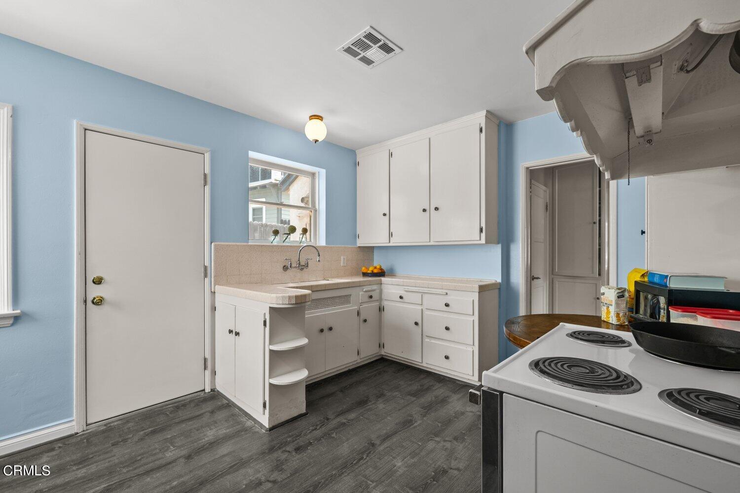 1807 Alpha Road Glendale, CA 91208 - Photo 5 of 26 a kitchen with white cabinets and white appliances