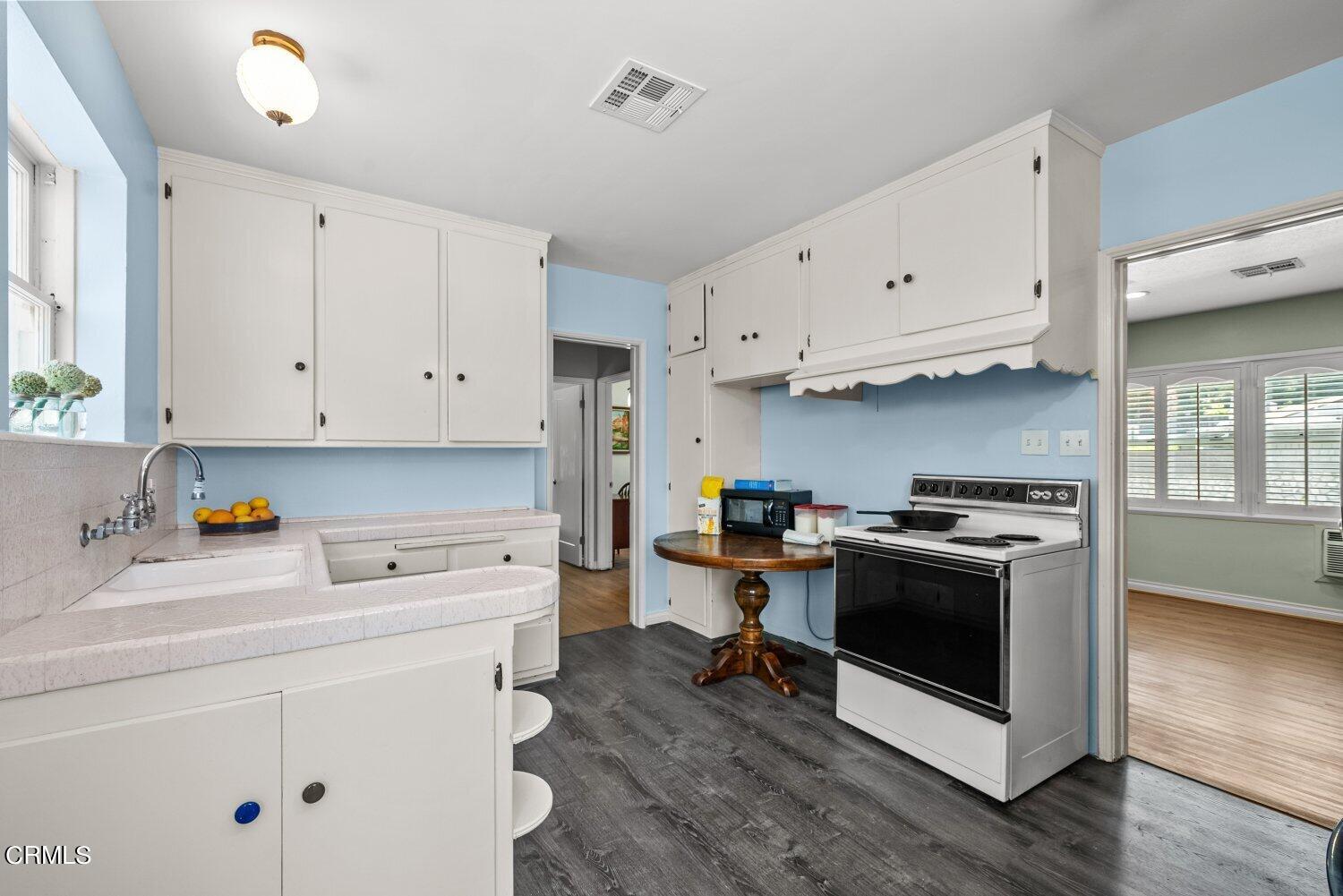 1807 Alpha Road Glendale, CA 91208 - Photo 6 of 26 a kitchen with stainless steel appliances a stove a sink and white cabinets