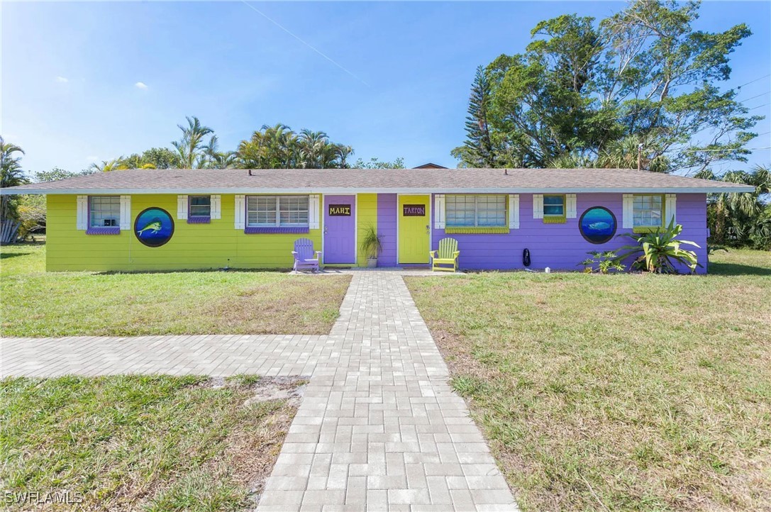 11093 Kelly Road Fort Myers, FL 33908 - Photo 2 of 12 a front view of a house with garden