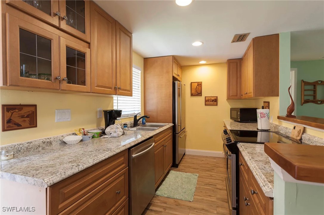 11093 Kelly Road Fort Myers, FL 33908 - Photo 3 of 12 a kitchen with stainless steel appliances granite countertop a sink stove and refrigerator