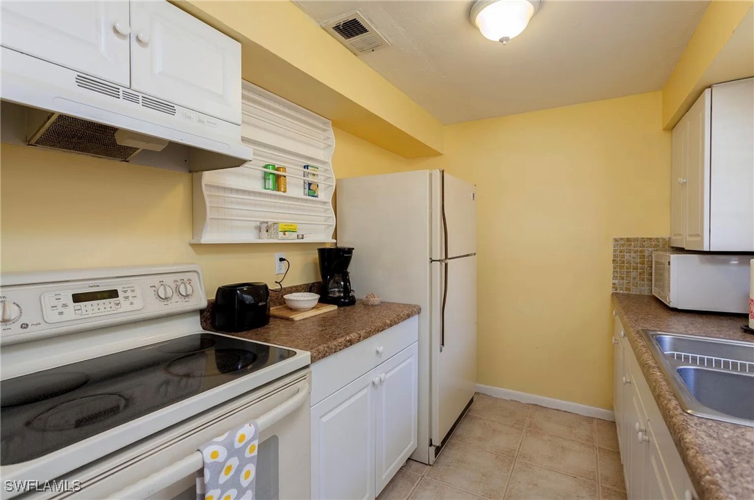 11093 Kelly Road Fort Myers, FL 33908 - Photo 5 of 12 a kitchen with stainless steel appliances granite countertop a sink and a refrigerator