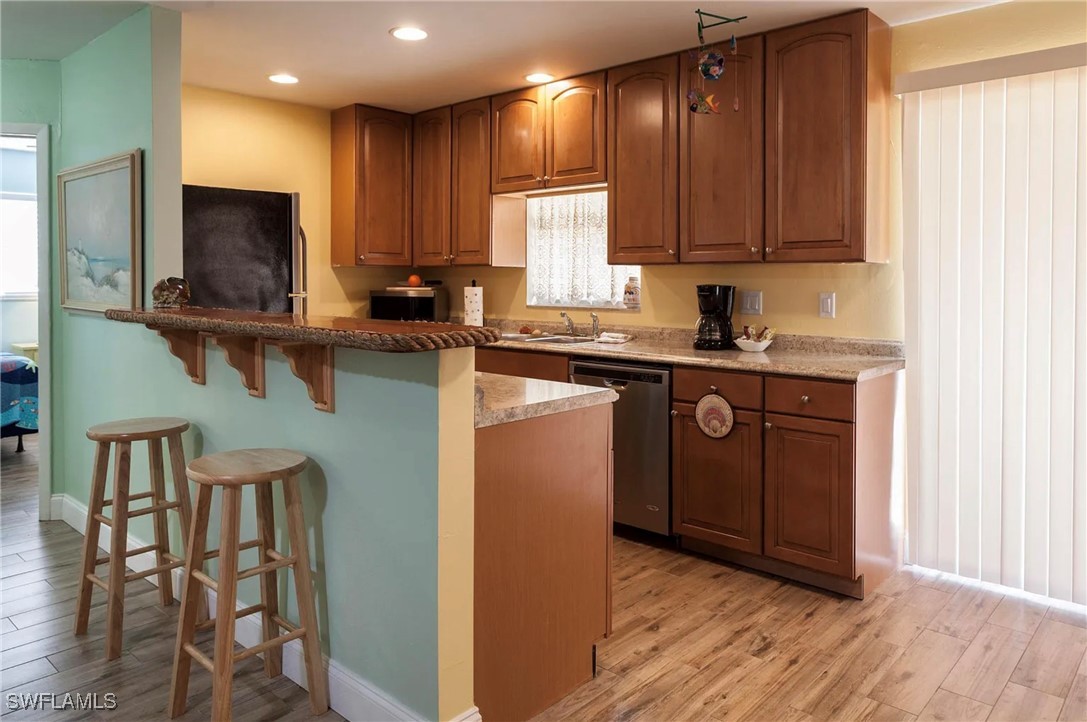 11093 Kelly Road Fort Myers, FL 33908 - Photo 8 of 12 a kitchen with stainless steel appliances granite countertop wooden cabinets a refrigerator and sink